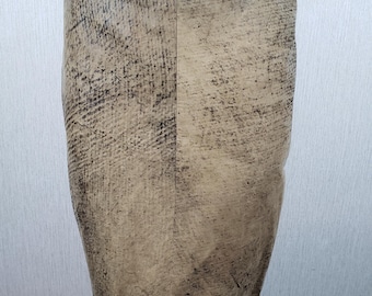 May include: A beige pencil skirt with a textured, distressed pattern. The skirt has a high waist and a knee-length hemline. The back of the skirt features a black leather panel at the waistband.