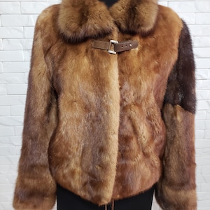 Stylish women&#39;s mink fur coat. Warm brown women&#39;s fur coat made of genuine mink fur