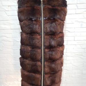 Stylish women&#39;s vest made of genuine rabbit fur and black leather. Warm women&#39;s fur vest with a metal zipper.