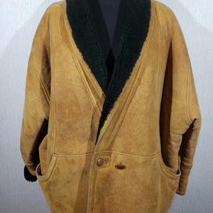 Wonderful women&#39;s warm sheepskin coat made of genuine pleasant sheep fur. Stylish brown sheepskin coat with buttons.