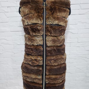 Stylish women&#39;s vest made of genuine rabbit fur and black leather. Warm women&#39;s fur vest with a metal zipper.