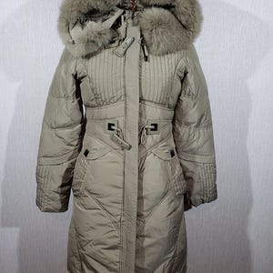 Reliable women's olive-colored jacket with a hood. Stylish insulated down jacket with a plastic zipper.