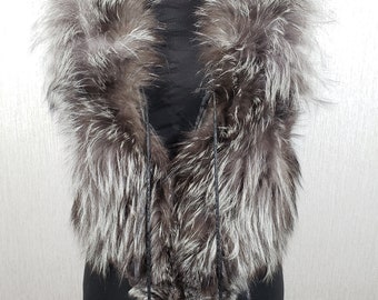 Stylish women's vest made of natural polar fox fur and black leather. Warm women's fur vest with a metal zipper.