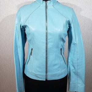 Veste en cuir pour femme fiable avec une fermeture éclair en métal. Veste en cuir pour femme simple de couleur bleue. Blouson en cuir bleu.
