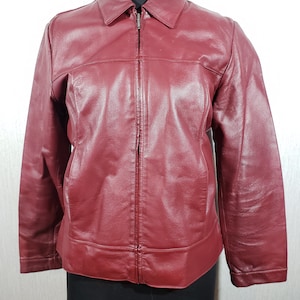 Blouson femme en cuir rouge. Blouson femme en cuir bordeaux avec fermeture éclair en métal.