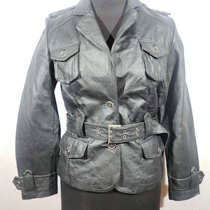 Süße schwarze Damen Lederjacke. Schwarze Damen Lederjacke mit Knöpfen und Gürtel.
