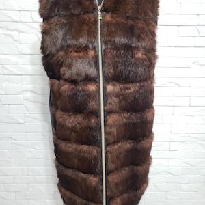 Stylish women&#39;s vest made of genuine rabbit fur and black leather. Warm women&#39;s fur vest with a metal zipper.