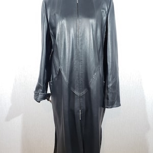 Veste en cuir longue et élégante pour femme. Manteau noir en cuir véritable avec une fermeture éclair en métal.