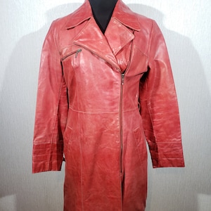Stylish red women&#39;s leather raincoat. Cute women&#39;s leather jacket with a metal zipper.