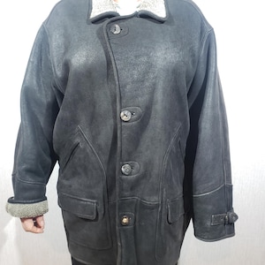 Wonderful men&#39;s black sheepskin coat with buttons. Stylish men&#39;s sheepskin coat with gray fur.