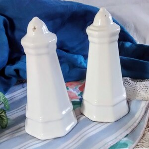 Puede incluir: Un juego de dos saleros y pimenteros de cer&aacute;mica blanca con un dise&ntilde;o geom&eacute;trico. Los saleros tienen forma de peque&ntilde;as torres con una base cuadrada y una parte superior puntiaguda.