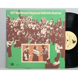 May include: A vintage record album cover featuring a large group of people gathered together at the 1977 Northwest Regional Folklife Festival. The cover is green and brown with the text "1977 Northwest Regional Folklife Festival" printed in white.