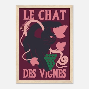 Peut inclure: Impression d'art encadrée avec un chat noir, des raisins et des vignes. Le texte "LE CHAT DES VIGNES" est en rose. Le fond est bordeaux foncé. L'œuvre a un style vintage, Art Nouveau.