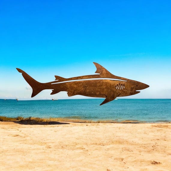 Rusty Shark wall art. Made out of 18 gauge steel. Has sawtooth Hanger welded on the back. Had a rust patina for a rustic look.