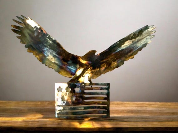 Eagle Flag yard and wall art. Flame finish with gloss clear coat. Made out of 16-gauge steel wall art or use detachable 12 in yard stakes