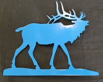 May include: A blue metal silhouette of an elk with large antlers. The elk is standing on a blue base.