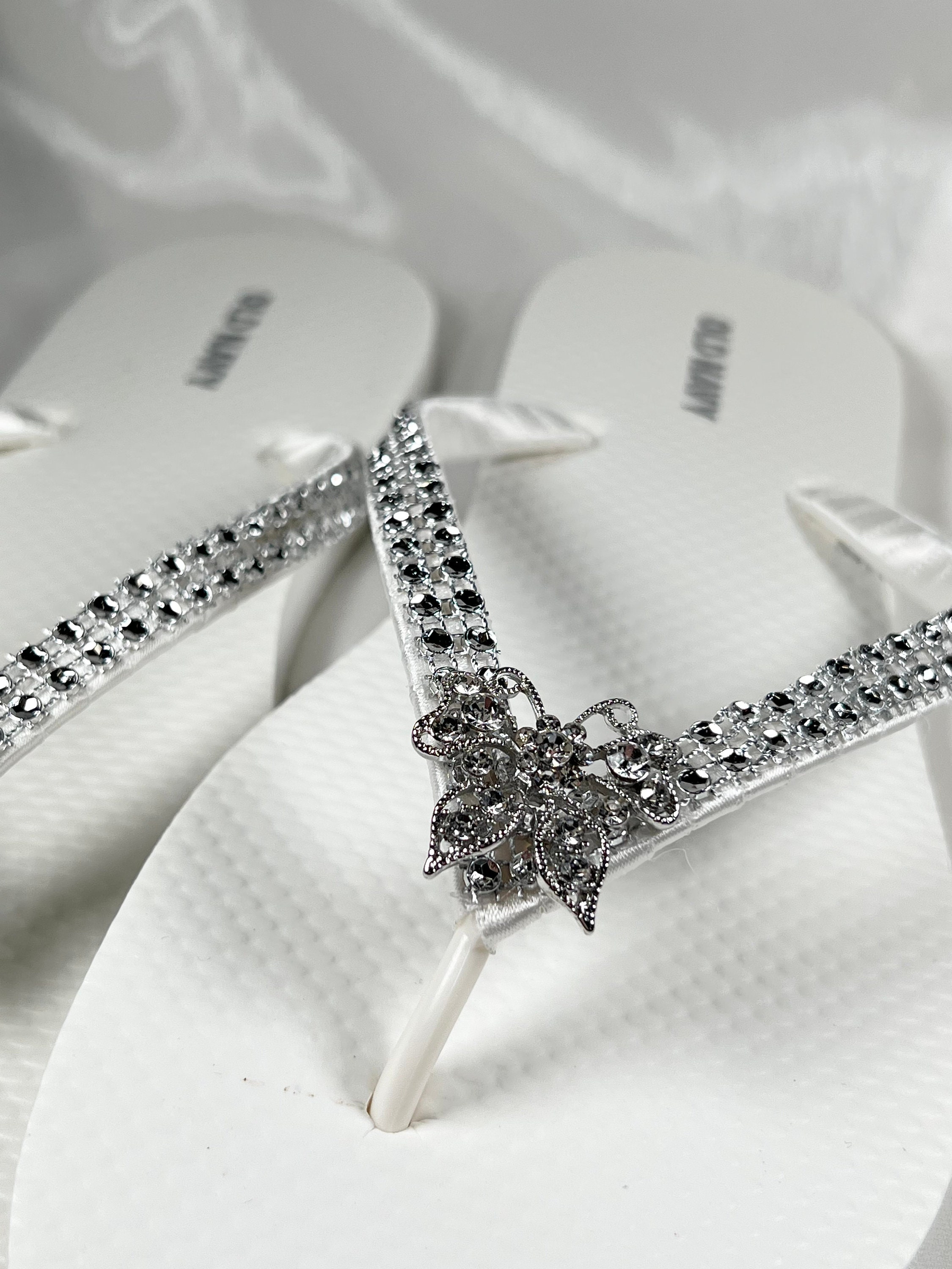 White jeweled store flip flops