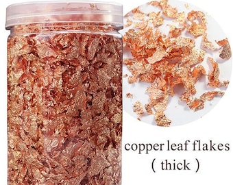 May include: A clear jar filled with copper leaf flakes. The jar has a white label that reads "copper leaf flakes (thick)".