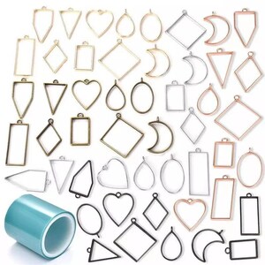 May include: Assortment of metal pendant frames in various shapes and sizes, including circles, ovals, hearts, squares, diamonds, triangles, and crescents. The frames are in gold, silver, and black finishes.