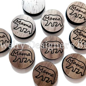 May include: Ten round wooden ornaments with a brown wood grain finish. Each ornament features a black silhouette of a bear with the word "Mama" written above it.