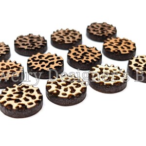 Pu&ograve; includere: Una collezione di dieci decorazioni rotonde in legno per l'artigianato con un motivo a stampa leopardata. Le decorazioni sono in tonalit&agrave; di marrone, beige e bianco.