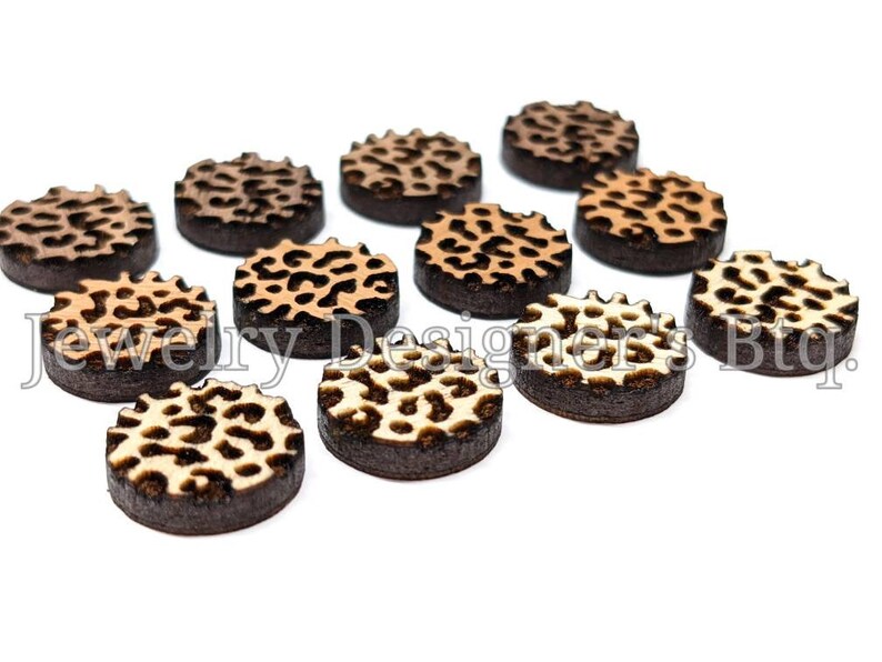 Pu&ograve; includere: Una collezione di dieci decorazioni rotonde in legno per l'artigianato con un motivo a stampa leopardata. Le decorazioni sono in tonalit&agrave; di marrone, beige e bianco.