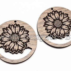 May include: Two round wooden earrings with a cutout design. Each earring features a laser-cut sunflower design.