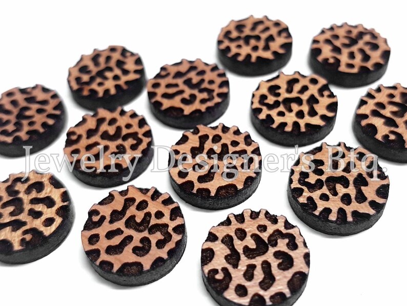 Pu&ograve; includere: Dodici decorazioni rotonde in legno per l'artigianato con un design a stampa leopardata. Le decorazioni hanno un diametro di circa 2,5 cm e un bordo nero.