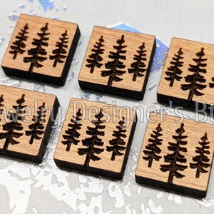 Puede incluir: Seis cuadrados de madera con un dise&ntilde;o de tres pinos cortado con l&aacute;ser. Los cuadrados son de color marr&oacute;n claro con un borde marr&oacute;n oscuro.