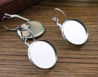 Può includere: Due basi per orecchini in argento con montature rotonde, piatte e argentate. Le montature hanno un diametro di circa 2,5 cm.