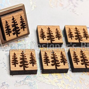 Puede incluir: Seis cuadrados de madera con un dise&ntilde;o de tres pinos grabado con l&aacute;ser en cada uno. Los cuadrados miden aproximadamente 2,5 cm por 2,5 cm.
