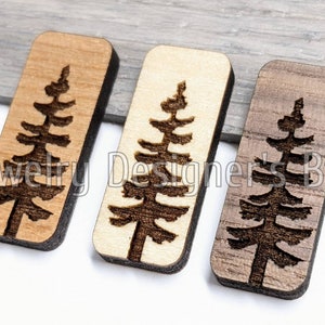 K&ouml;nnte beinhalten: Drei rechteckige Holzornamente mit einem lasergeschnittenen Design eines Kiefernbaums. Die Ornamente sind in drei verschiedenen Holzt&ouml;nen gehalten: hellbraun, natur und dunkelbraun.