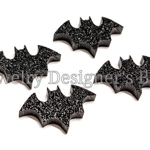 Può includere: Quattro forme di pipistrello nere con glitter, ognuna con un design leggermente diverso. Questi pipistrelli sono perfetti per l'artigianato e la decorazione per Halloween.