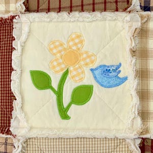 Peut inclure: Un carr&eacute; de tissu blanc avec une fleur jaune &agrave; motif vichy blanc et jaune, des feuilles vertes et un oiseau bleu &agrave; motif vichy blanc et bleu.