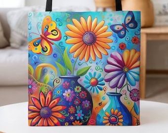 May include: A colorful tote bag with a floral design featuring bright yellow, orange, purple, and blue flowers. The bag has black straps and a blue background with butterflies.