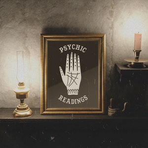 Może przedstawiać: Wydruk w ramie z czarnym tłem i białą ręką z liniami. Tekst "PSYCHIC READINGS" znajduje się nad i pod ręką.