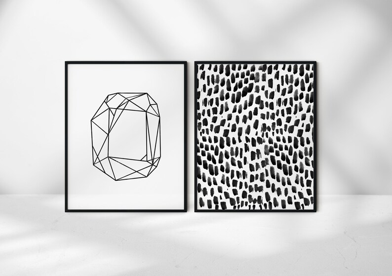Puede incluir: Dos impresiones enmarcadas en blanco y negro. La impresi&oacute;n de la izquierda es un dise&ntilde;o geom&eacute;trico de un diamante. La impresi&oacute;n de la derecha es un patr&oacute;n abstracto en blanco y negro de puntos.