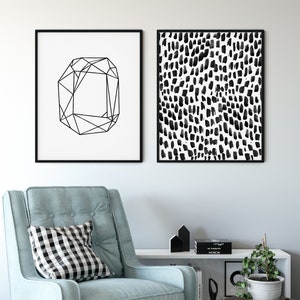 Puede incluir: Dos impresiones enmarcadas en negro en una pared blanca. La impresi&oacute;n de la izquierda presenta un dise&ntilde;o geom&eacute;trico en blanco y negro. La impresi&oacute;n de la derecha presenta un patr&oacute;n abstracto en blanco y negro de puntos.