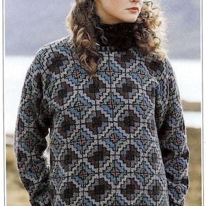 May include: A woman wearing a dark blue, grey, and white patterned sweater with a high neck. The sweater has a geometric design.