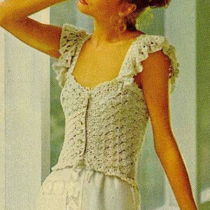 May include: A white crocheted top with a ruffled neckline and short sleeves. The top has a button-up front and a fitted silhouette.