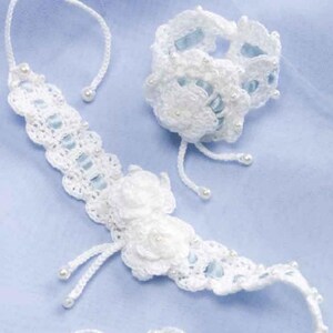 May include: A white crocheted necklace and bracelet set with blue ribbon accents and pearl beads.