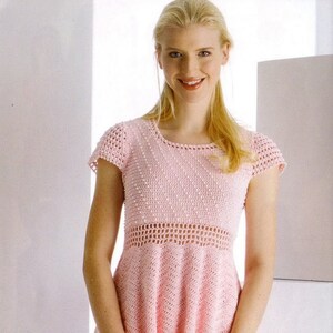 May include: A pink crocheted top with a delicate openwork design and a matching pink crocheted bag. The top has short sleeves and a fitted bodice with a flared skirt. The bag has a drawstring closure and a long strap.