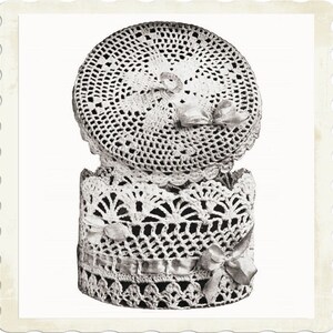 May include: A crocheted box with a lid, featuring a delicate white lace pattern and a satin ribbon bow. The box is perfect for storing small items like jewelry or trinkets.