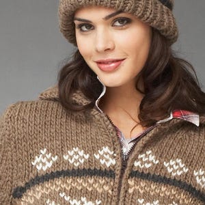 May include: A brown knitted cardigan with a zipper closure and a white reindeer pattern. The cardigan has a brown knit hat with a white pom pom on top.