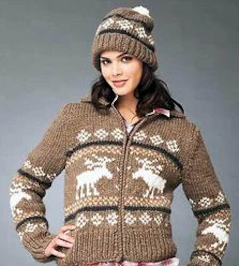 May include: A brown knitted cardigan with a zipper closure and a white reindeer pattern. The cardigan has a white pom-pom on the hood.
