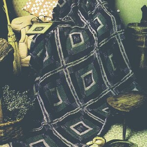 May include: A black and green crocheted throw blanket with a square pattern. The blanket is draped over a chair and a wooden stool.