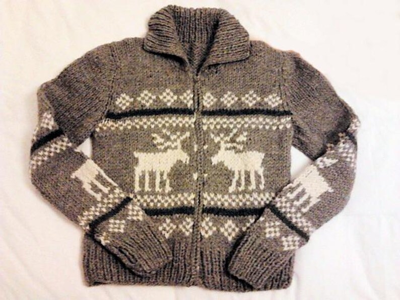 May include: A gray knitted cardigan with a white reindeer pattern. The cardigan has a zipper closure and a collar.