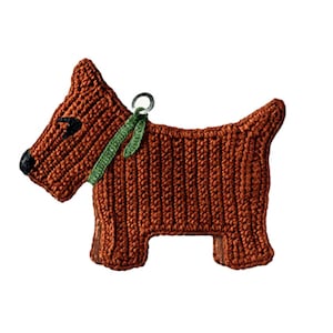 May include: A rust-colored crocheted dog ornament featuring a textured yarn surface, a small black nose, black eye detail, and a thin green crocheted collar. A small silver-toned metal ring is attached to the top of the collar for hanging purposes.