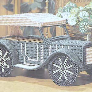 Peut inclure: Modèle de voiture vintage fait à la main. La voiture est principalement gris foncé avec des détails blancs, y compris les roues et les éléments décoratifs. Le toit et la calandre avant sont beiges. Les roues présentent un motif en forme de flocon de neige. Un objet décoratif charmant.
