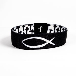 May include: Black wristband with a white fish symbol on the front and a pattern of white crosses on the back.